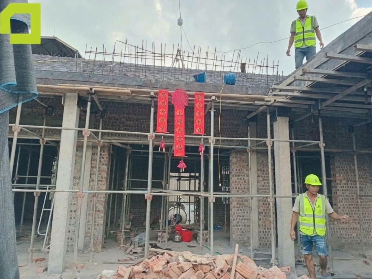Công trình nhà tứ hợp viện thi công với hệ cột bê tông cốt thép, tường gạch, giàn giáo và cốt thép chờ tại khu vực mái