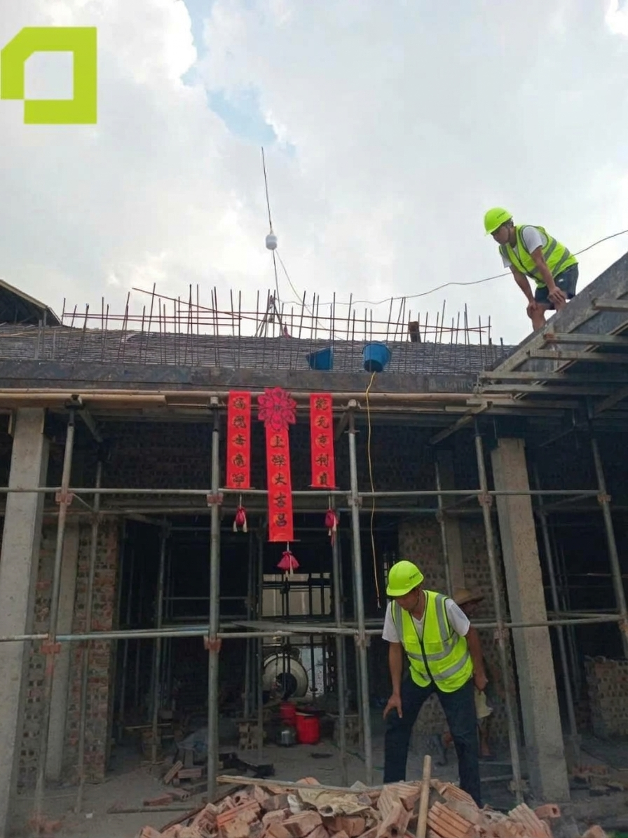 Công nhân kiểm tra khu vực thi công kết cấu nhà ở với hệ giàn giáo, cột bê tông, tường gạch và cốt thép