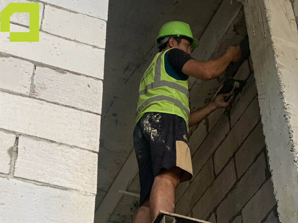 Thợ thi công xây tường và xử lý mạch vữa tại công trình