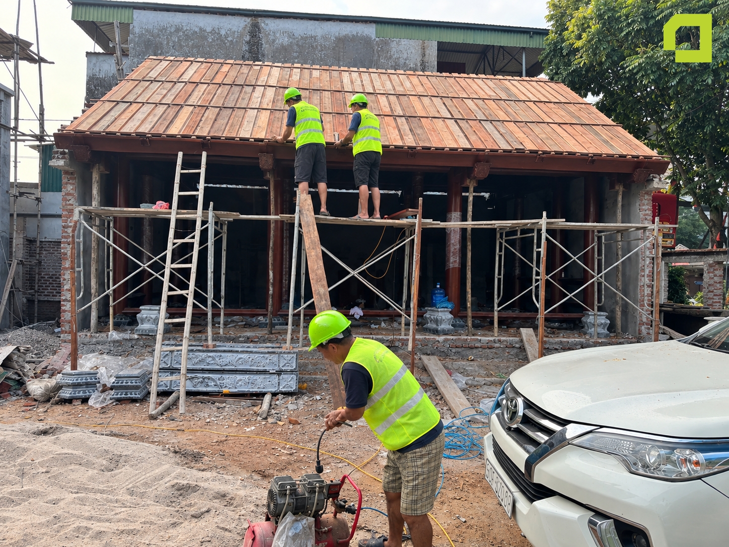 Nhóm thợ đang thực hiện công đoạn hoàn thiện phần mái và kết cấu nhà gỗ truyền thống (nhà cổ phong).